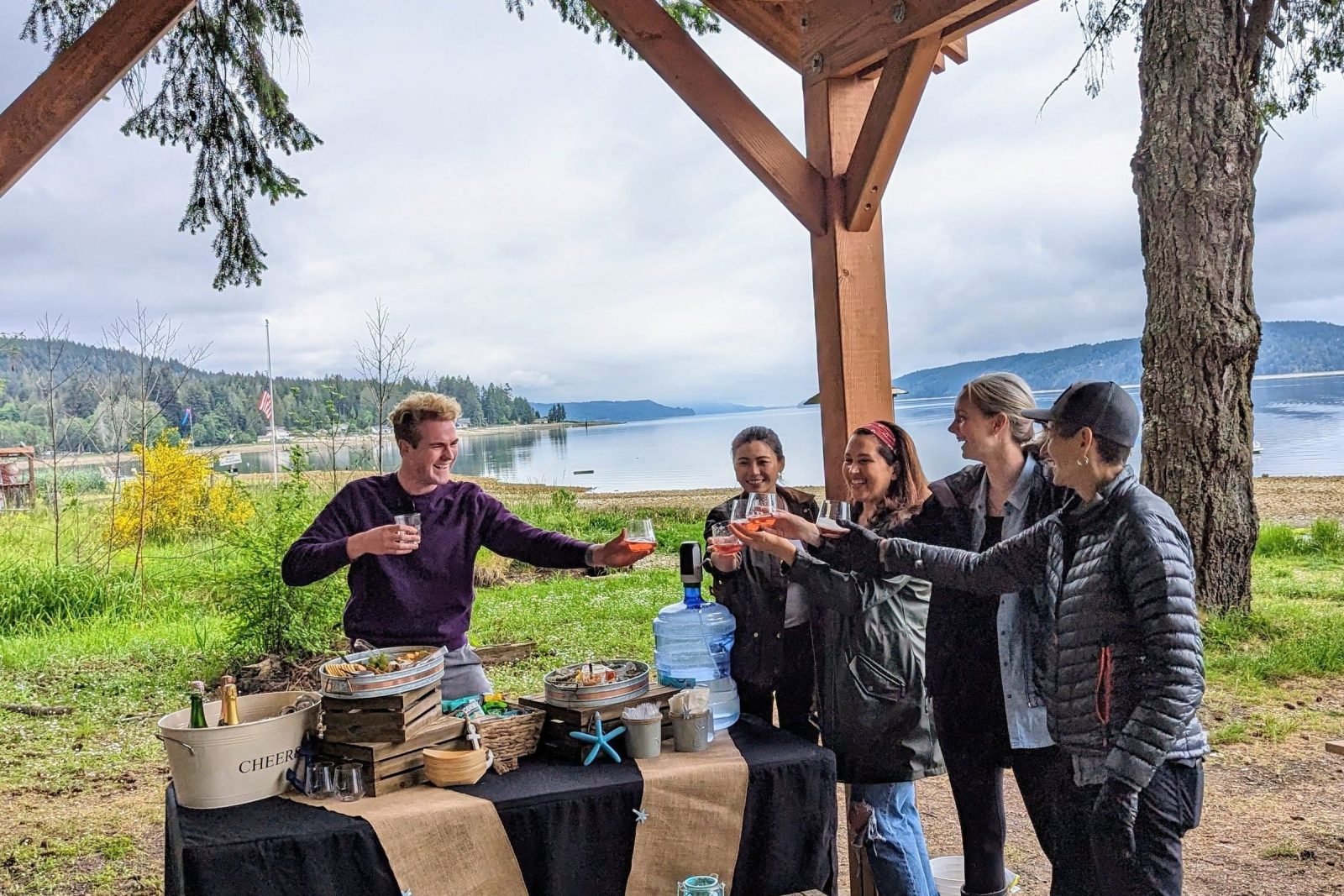A private group raises a toast at an outdoor table after foraging